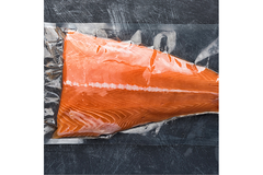 Image Vacuum-packed salmon fillet on dark surface